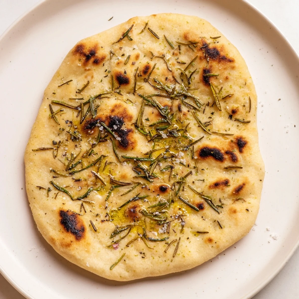 Golden-brown quick homemade flatbread with rosemary, offering a tempting aroma and flavor.