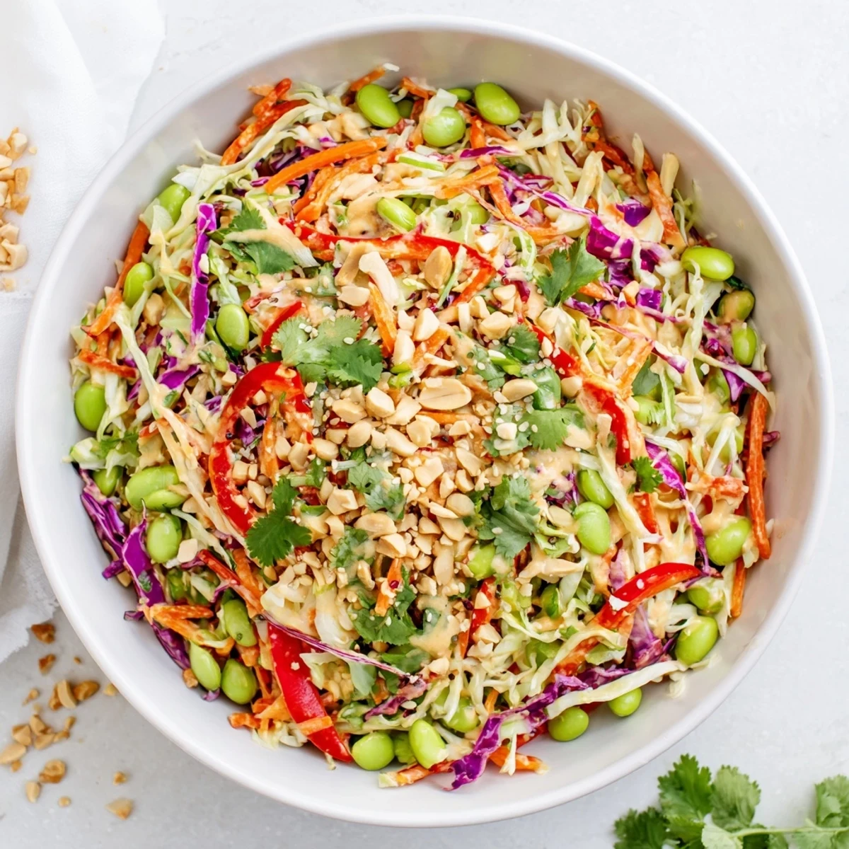 Close-up of Crunchy Thai Peanut Salad showcasing crunchy cabbage, edamame, and sesame seeds coated in tangy peanut dressing.