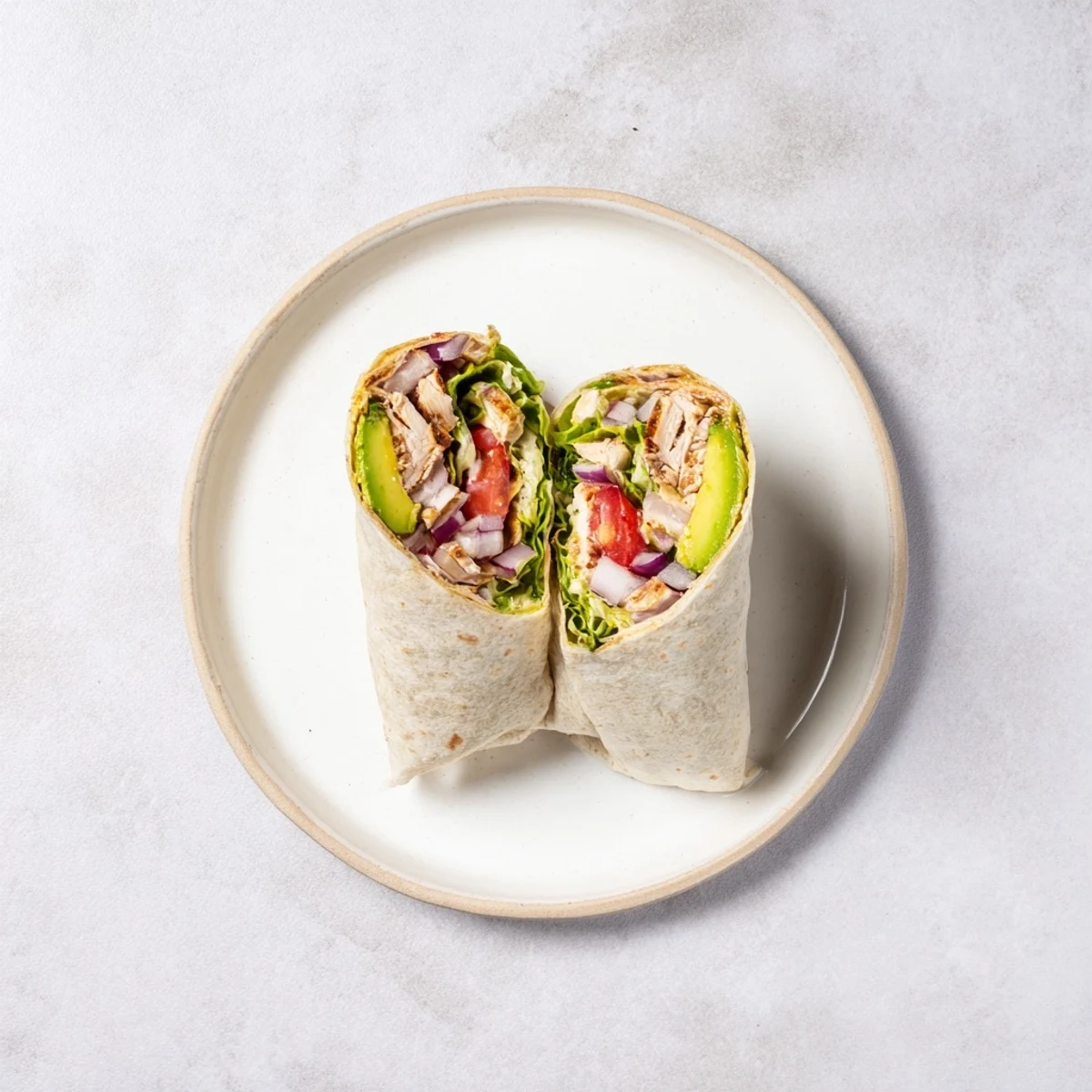 Grilled smoky chipotle chicken breast nestled in a soft flour tortilla with vibrant avocado slices and shredded lettuce for a flavorful lunch.