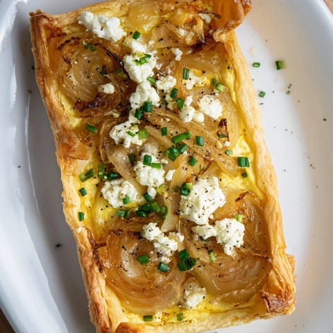A freshly baked Decadent Caramelized Onion and Goat Cheese Tart, perfect for a special occasion.