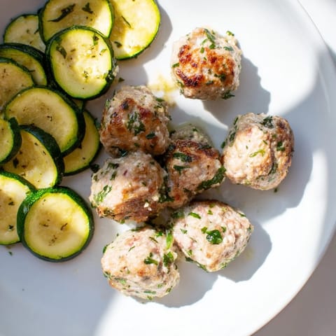 Visualize the savory aroma of Easy Sheet Pan Turkey Meatballs with perfectly cooked zucchini and herbs.