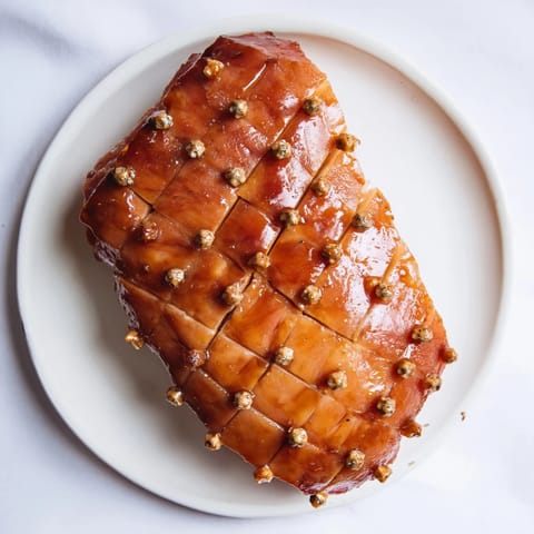 Juicy slices of Slow-Cooked Honey Glazed Ham with spiced honey glaze, served with orange slices for a vibrant look.