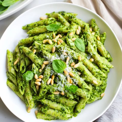 Tempting view of the best 15-minute creamy pesto pasta, perfectly coated with vibrant green sauce.