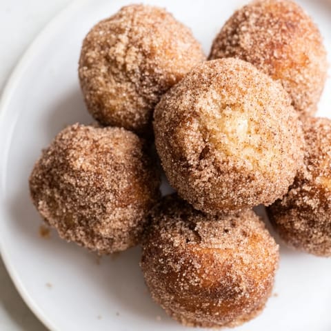 Warm, glazed air fryer cinnamon donuts dusted with cinnamon sugar, perfect for a sweet breakfast.