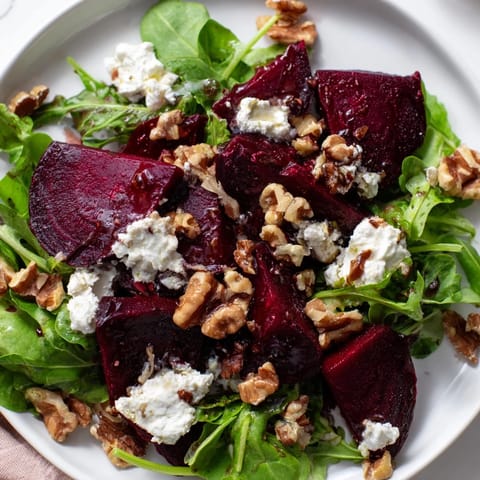 Freshly tossed Beet and Goat Cheese Salad, showcasing colorful beets and a tangy balsamic vinaigrette drizzle.