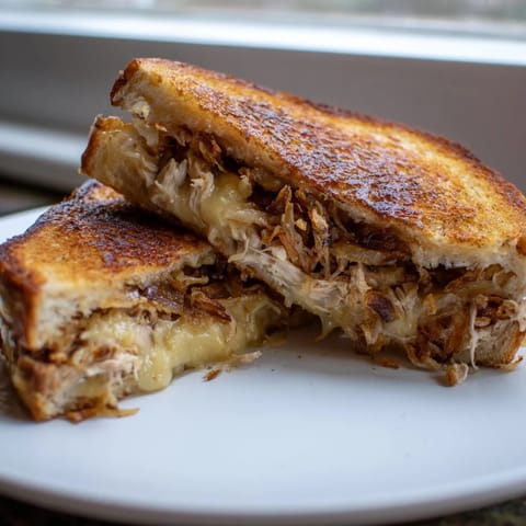 Crispy layers and melty cheese: a delicious close-up of a Crispy Shallot Chicken Grilled Cheese sandwich.