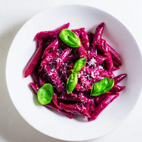 Creamy Pink Pasta with Beet Cream swirls with roasted garlic and tangy lemon notes, served in a shallow bowl for a cozy vegetarian dinner.  