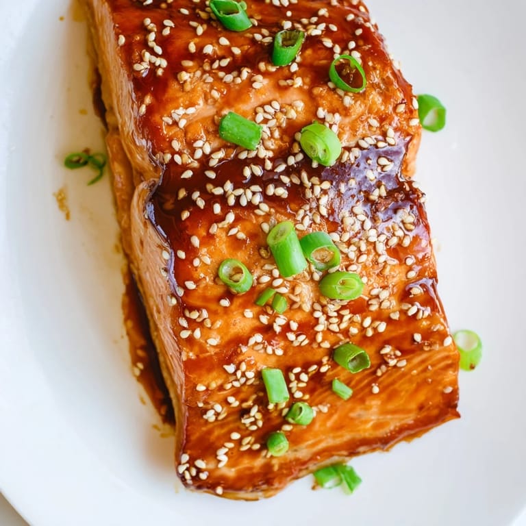 Tender, flaky Ginger Soy Glazed Salmon with a beautiful sheen, garnished with green onions.