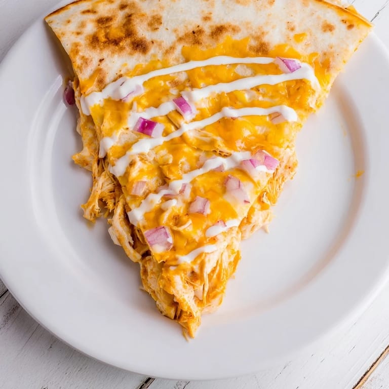 A steaming plate of delicious Buffalo Chicken Quesadilla, filled with juicy chicken and melted cheese.