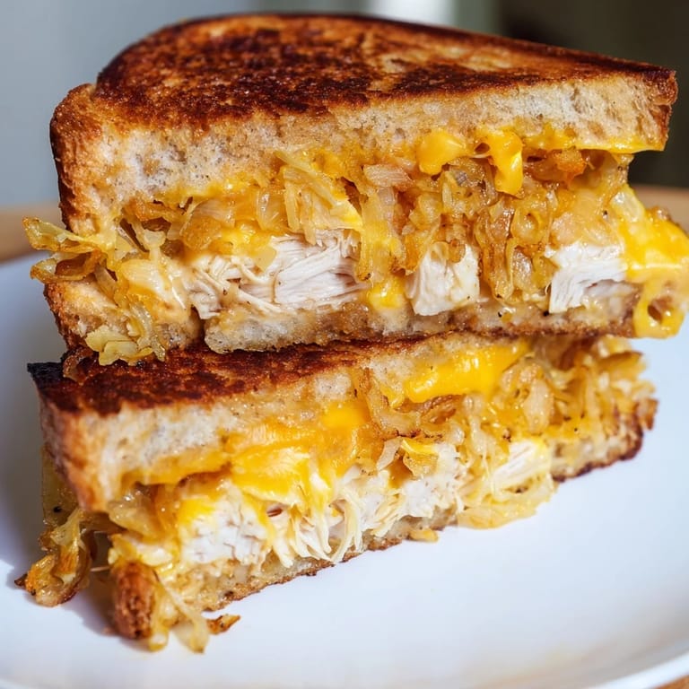 Hot, cheesy, and satisfying: a freshly grilled Crispy Shallot Chicken Grilled Cheese ready to be eaten.
